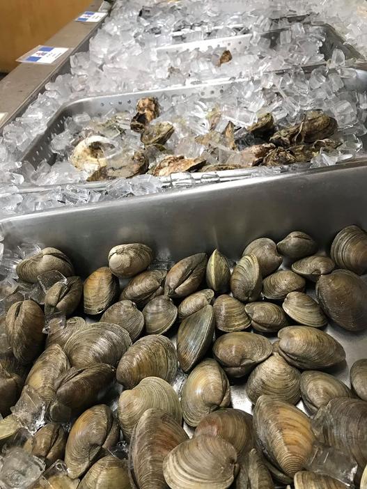 Color Photo of Side View of Shellfish on Ice in Cooler in Market